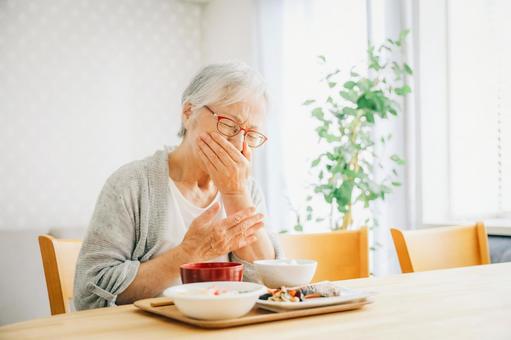 入れ歯があっていなくて痛がっている女性